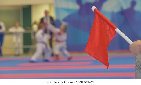 Red Flag In Front Of Teenager Girls Fighting At The Karate Tournament