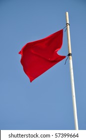 Red Flag Waving Against Blue Sky