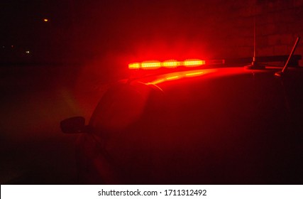 Red Flashing Light Of A Police Car On The Background Of A Night Street