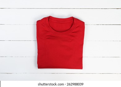 Red Folded T-shirt On White Wooden Background. Tshirt Mockup