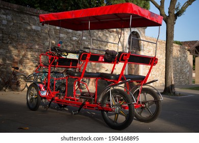 Red Four Wheel Surrey Bicycle Parked At The Square