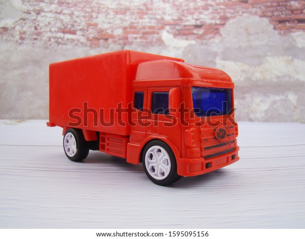 Red four-wheeler truck by\
the wall