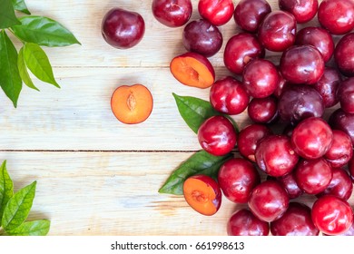 Red fresh plums with leaves on wooden background  - Powered by Shutterstock