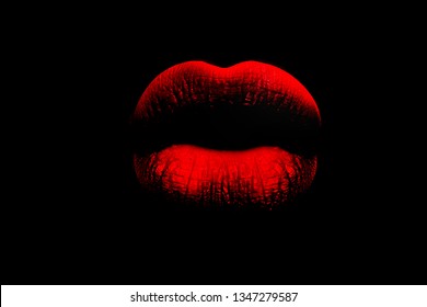 Red full lips on black background. The woman's lips. Lush lips like a kiss. Red and pouting. Erotica, sex, temptation.