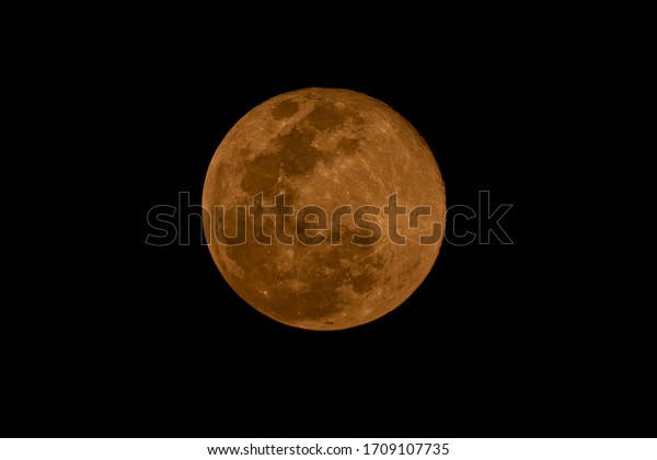 Red full moon close up on night sky background,
surface moon on black background and not star in sky, moon is
planet of earth in univers