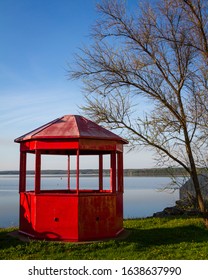 A Red Gazebo Structure And Tree Beside A Lake In Pictou NS, Canada. 