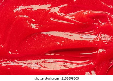 Red Gel Texture. Cosmetic Clear Liquid Cream Smudge. Skin Care Product Sample Closeup. Toothpaste Or Wax Background