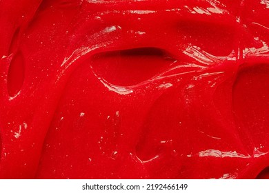 Red Gel Texture. Cosmetic Clear Liquid Cream Smudge. Skin Care Product Sample Closeup. Toothpaste Or Wax Background