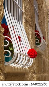 red geraniums on the window with bars, Malta