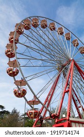 Red Giant Wheel In Front Of A Blue Summer Sky During The Day, No People Sitting In The Gondolas, The Festival Starts In The Evening When It Gets Dark