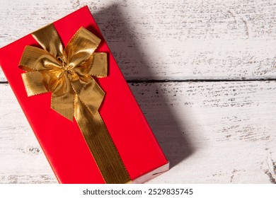 red gift box with golden ribbon isolated on wooden background, gift box on wooden table, top view, time to gift, 
celebration christmas gift box. christmas present - Powered by Shutterstock