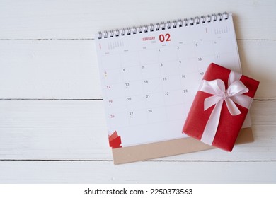 Red gift box on calendar isolated on white wooden background with. Valentine's day concept. Planning scheduling agenda, Event, organiser valentines day. Flat lay, top view. - Powered by Shutterstock