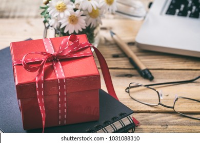 Red gift box with red ribbon, blur office desk background - Powered by Shutterstock