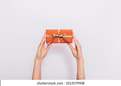 Red gift box with ribbon in female hands over head on white background - Shutterstock ID 1013579908