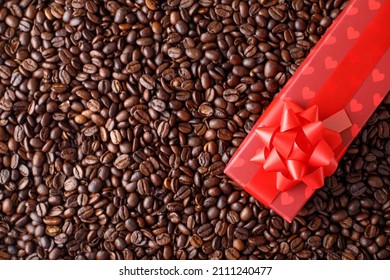 Red gift box with ribbon and hearts on a background of coffee beans. Top view card greeting with coopy space. - Powered by Shutterstock