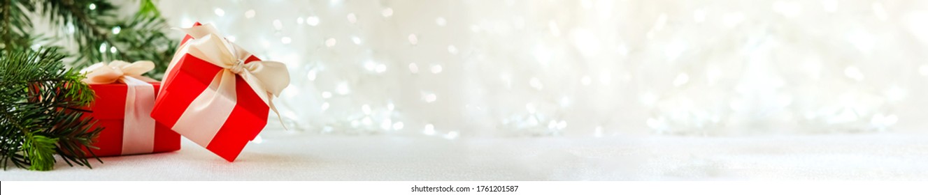 red gift boxes with ribbons on a white background with garlands. Next to the tree branch. The concept of Christmas. Long banner with space for text - Powered by Shutterstock