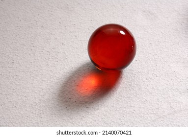 red glass marble, ball, marble on a white background