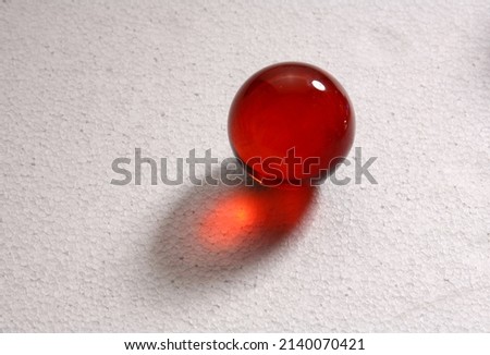 red glass marble, ball, marble on a white background