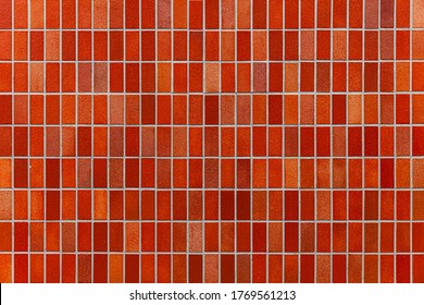 Red glazed ceramic brick wall texture and seamless background