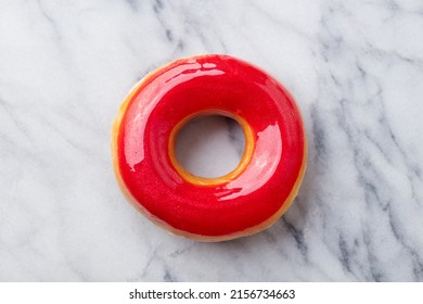 Red Glazed Donut On The Marble Table. Close Up. Top View.