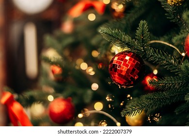 Red and gold Christmas decorations on the Christmas tree in the loft interior close-up.New Year's and Christmas background.Selective focus with shallow depth of field. - Powered by Shutterstock