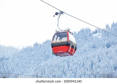 Red Gondola Car Lift On The Ski Resort Over Forest Trees