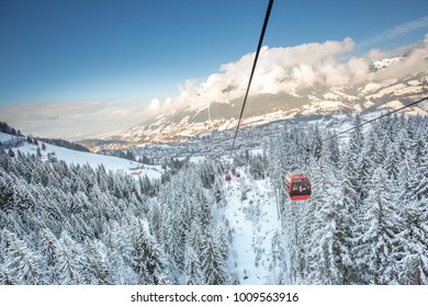 Red Gondola Car Lift On The Ski Resort Over Forest Trees