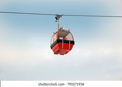 Red Gondola Car Lift On The Ski Resort Against Blue Sky