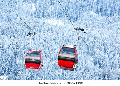 Red Gondola Car Lift On The Ski Resort Over Forest Trees 