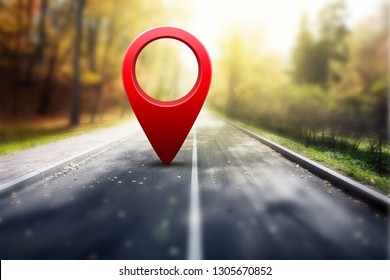 Roter GPS-Stift auf Asphaltstraße und Schönheitsherbstlandschaft