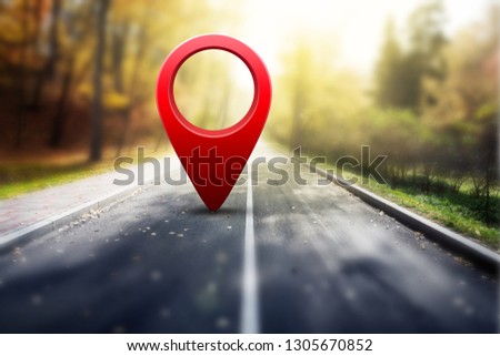 Red GPS pin on asphalt road and beauty autumn nature