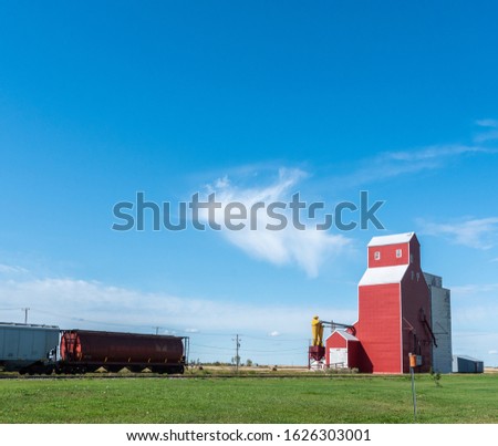 Red Grain Elevator and Grain Freight Train - Road trip through Saskatchewan, Central Canada