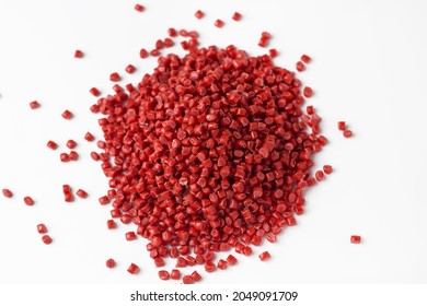 Red granules of polypropylene or polyamide on a white background. Plastics and polymers industry. Copy space.