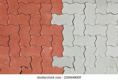 Red and gray interlocking concrete paver blocks. Irregular shaped tiles for outdoor pavement. Samples. background and texture