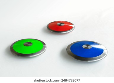 Red, green and blue color of athletics discus throw on an isolated white background - Powered by Shutterstock