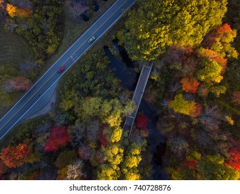 Red And Green Car Moving On The Road And Bicycle Path Bridge With Foliage Trees In Fall Season. Arial Photography. Bird Eye View, Drone Photography.