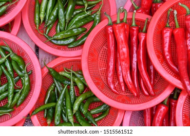 Red and green chile peppers in red bowls