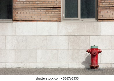 Red and green fire hydrant below two windows on the street in Montreal, Quebec, Canada.  No people, room on the left for copy.