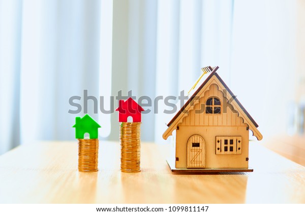 Red and green home model put on gold coins set put\
on a wooden table.Saving money exchange or credit and loan for\
business and real estate.For family success and happiness.         \
                  