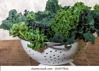 Red and green kale leaves in a white colander - Powered by Shutterstock