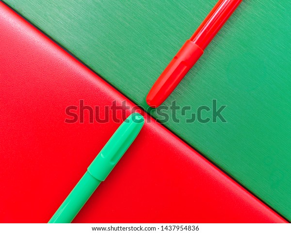Red and green markers and notebooks pattern,\
back to school concept.
