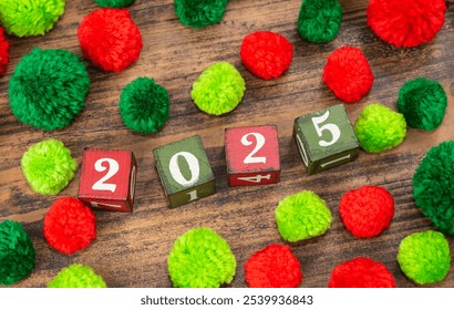 Red and green pompoms with wooden blocks 2025 on wood - Powered by Shutterstock