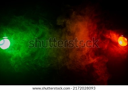 Red green smoke on a black background. 