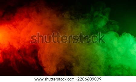 Red green smoke on a black background. 