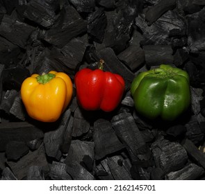 red, green and yellow capsicum on charcoal
