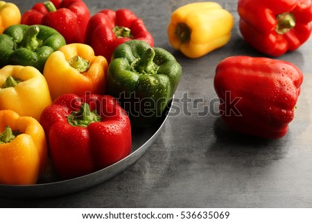 Red, green and yellow sweet bell peppers on table, close up