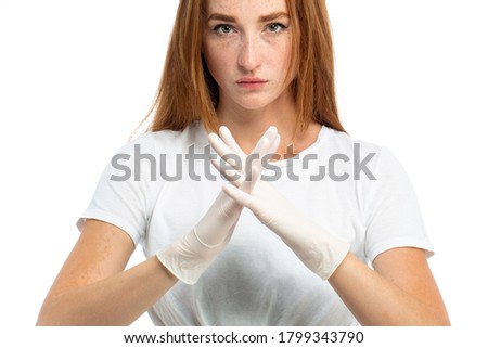 Red hair beautiful model in medical gloves at studio