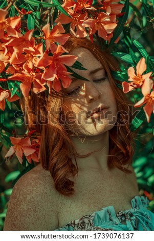 Similar – ein Mädchen mit blauen Augen und langem Haar, das sich mit einer Gerbera-Blüte bedeckt