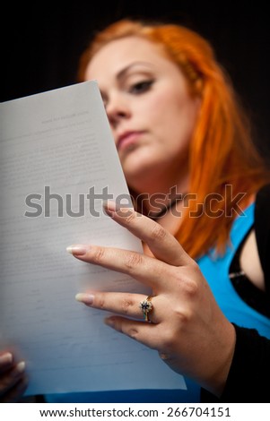 Red hair girl in pin-up style reading a letter
