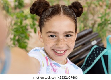 Red haired crazy little girl with freckles laughing while taking a selfie looking at camera in a park. Happiness, joy, technology, communications and friendship concept. - Powered by Shutterstock